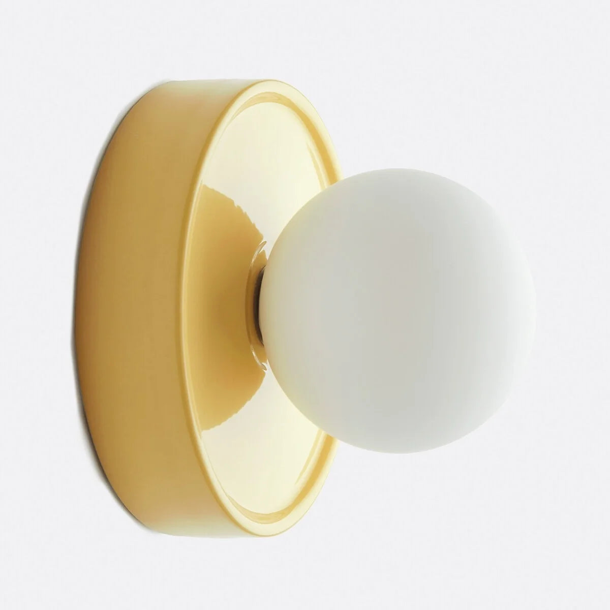 Modern ceramic orb wall sconce styled on a plain interior wall