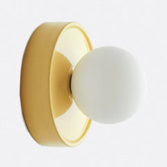 Modern ceramic orb wall sconce styled on a plain interior wall