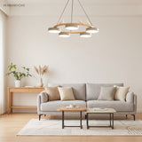 Wood ring chandelier with white shades over a grey sofa in a bright living room