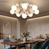 White globe cluster ceiling light lit above a dark timber dining table