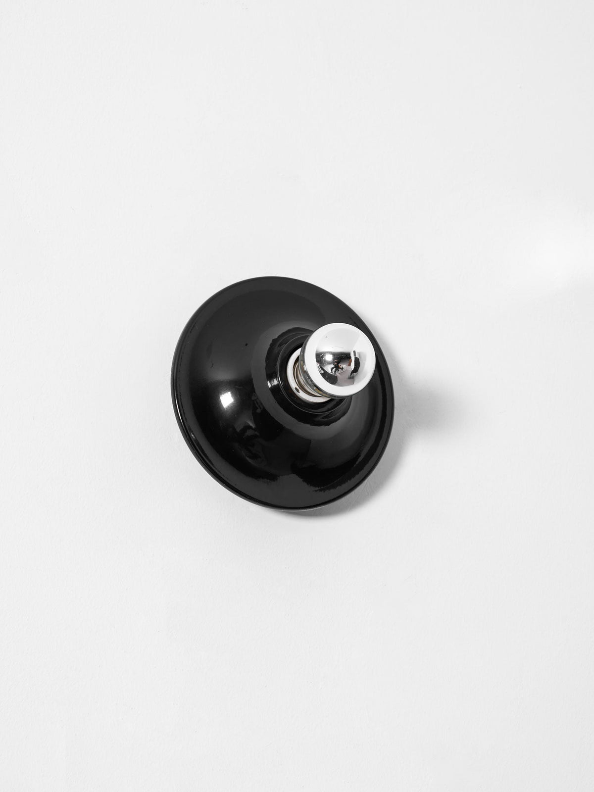 Black disc wall sconce angled with a mirror crown electroplated bulb