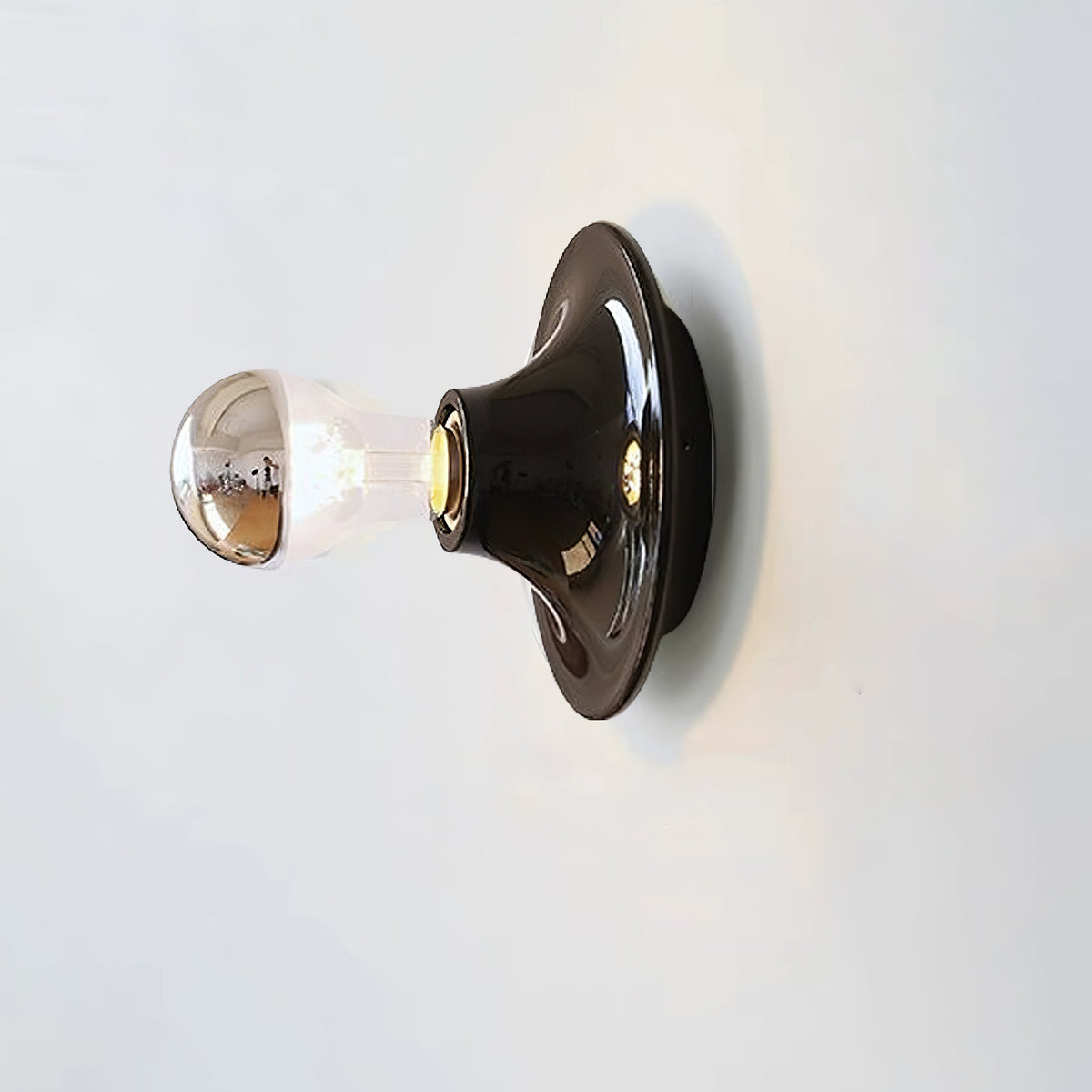 Black disc wall sconce fitted with a mirror crown electroplated bulb