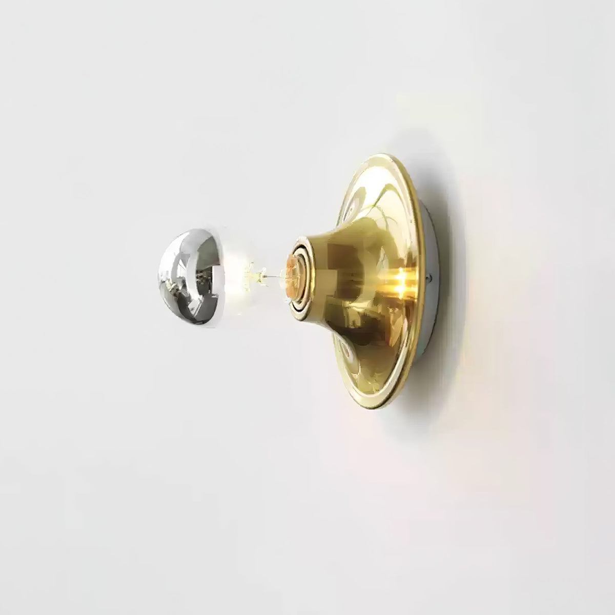 Brass disc wall sconce with an electroplated mirror crown bulb, side view