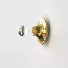 Brass disc wall sconce with an electroplated mirror crown bulb, side view