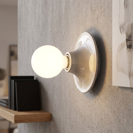 Modern flush mount wall sconce in nickel with a round white globe bulb