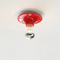 Red disc ceiling light mounted flush with an electroplated bulb facing down