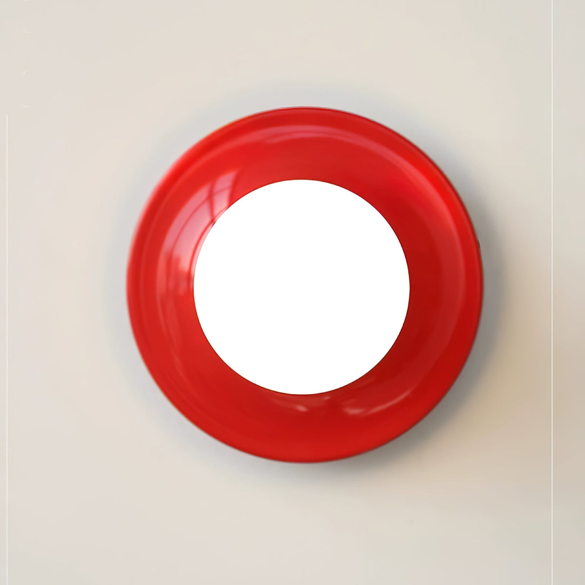 Red disc wall sconce seen face on with a round white bulb