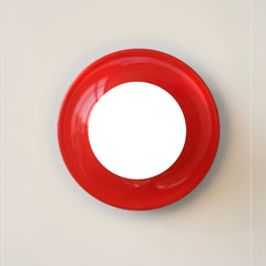 Red disc wall sconce seen face on with a round white bulb