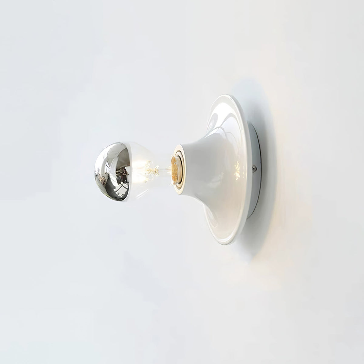 White disc wall sconce fitted with a mirror crown electroplated bulb