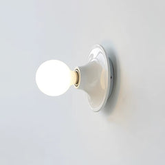White disc wall sconce with a large lit opal globe bulb