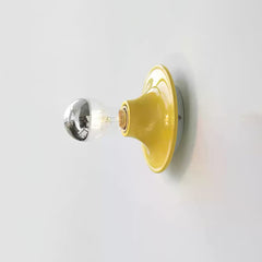 Yellow disc wall sconce with a mirror crown electroplated bulb, side view