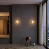 Pair of globe sconces on a dark plaster bedroom wall beside a mirror