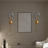 Modern glass globe wall sconce angled view on a brass stem