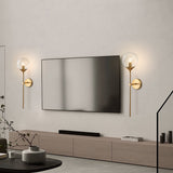 Modern glass globe wall sconce detail on a brass stem