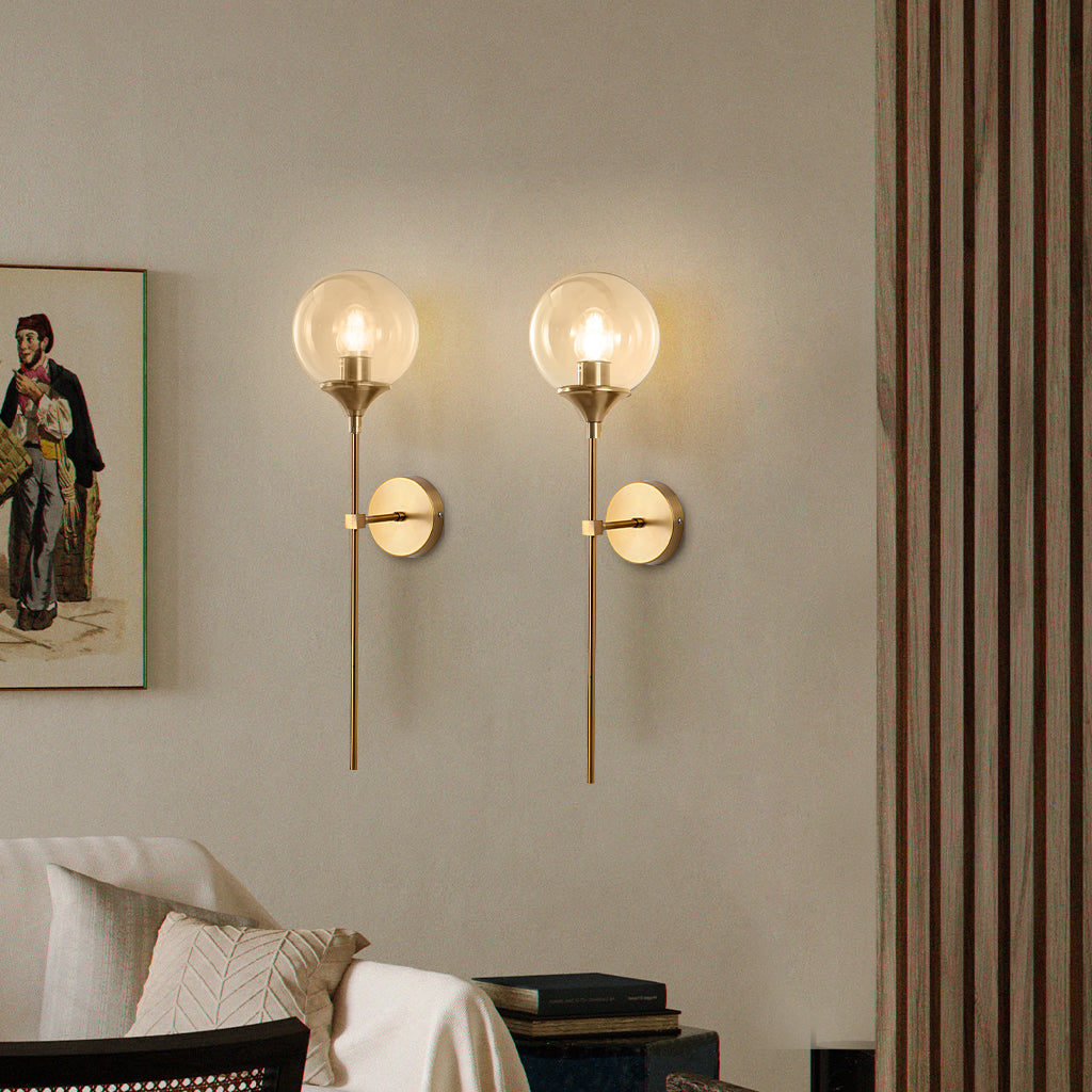 Modern glass globe wall sconce studio view on a brass stem
