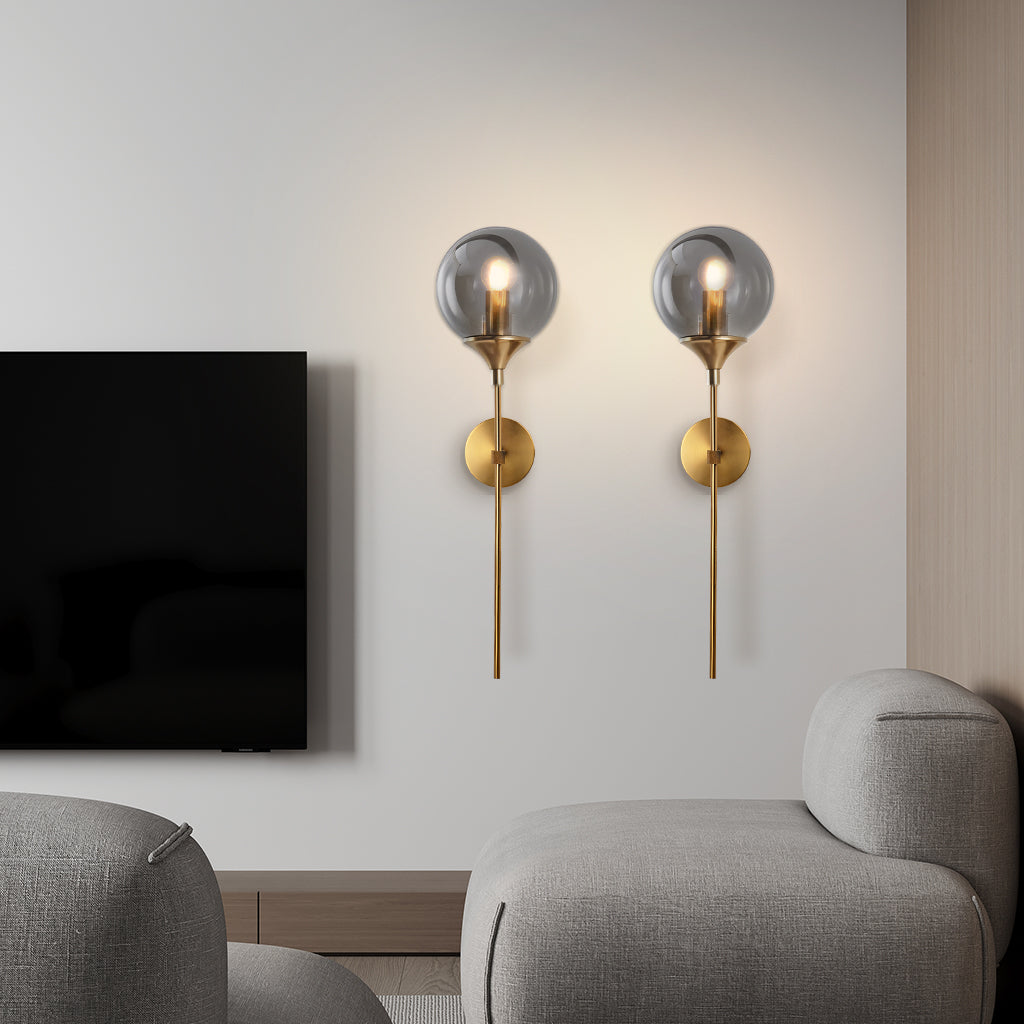 Modern glass globe wall sconce studio angle on a brass stem