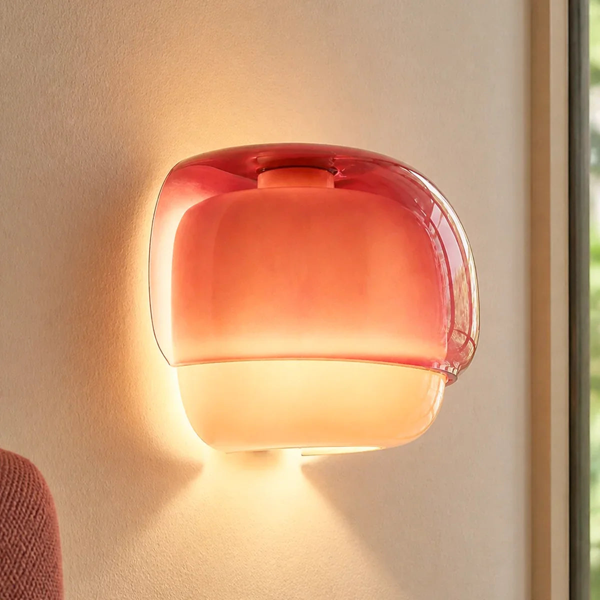 Modern glass wall sconce displayed alongside contemporary interior styling props