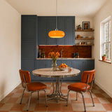 Orange glass pendant light in a blue-cabinet kitchen with checkerboard floor