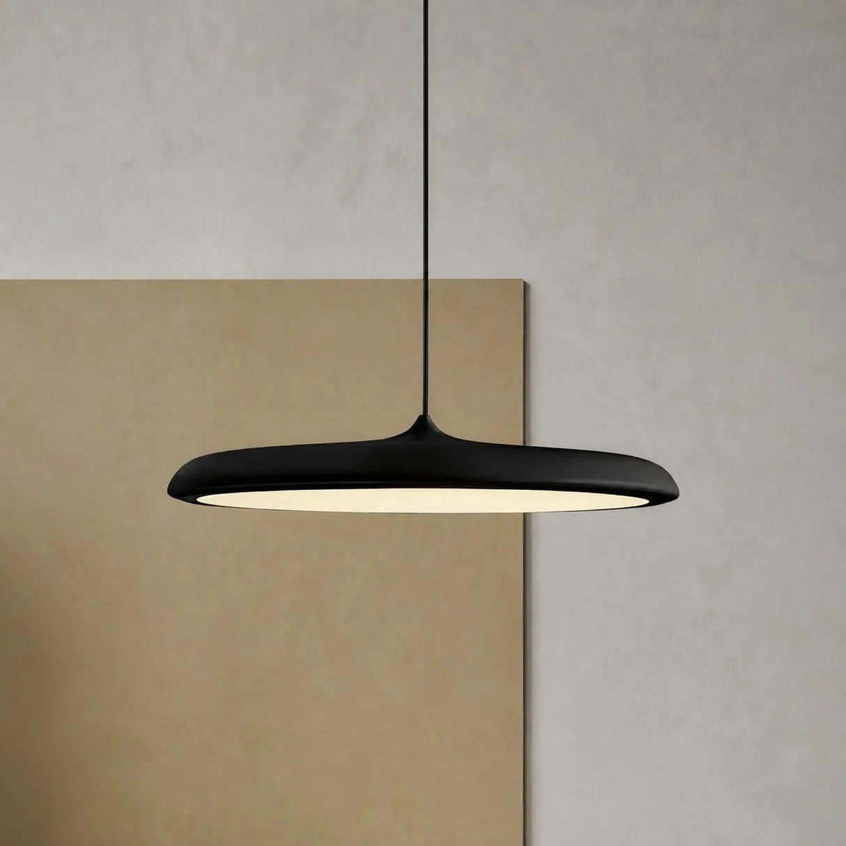 Underside of the disc pendant light showing the wide even glowing diffuser
