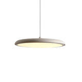 Green disc pendant light shown from the side against a plain studio backdrop