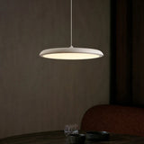 White disc pendant light shown from a raised angle against a plain backdrop