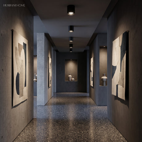 Surface mount spotlights washing artwork on dark blue gallery hallway walls