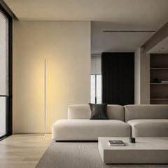 White floor lamp casting warm light near a beige sofa and jute rug