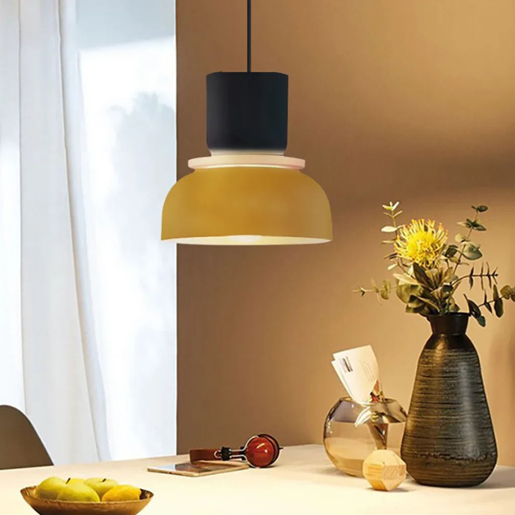 Navy and yellow single pendant over a warm dining table with a vase