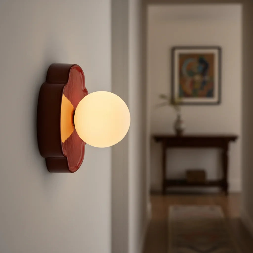 Beige orb wall sconce three-quarter view with rounded flower backplate