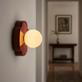 Beige orb wall sconce three-quarter view with rounded flower backplate