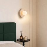 Mocha brown orb wall sconce with glowing white glass globe shade