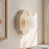 Red flower-shaped orb wall sconce studio shot with lit glass globe