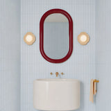 Side angle of the orb wall sconce showing the domed glass globe shade