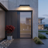 Black bar light mounted above a modern front door and glazing