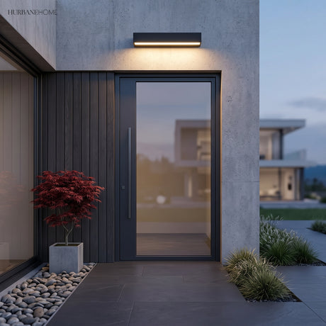 Black bar light mounted above a modern front door and glazing