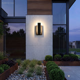 Rectangular wall sconce lighting a pale rendered column at dusk