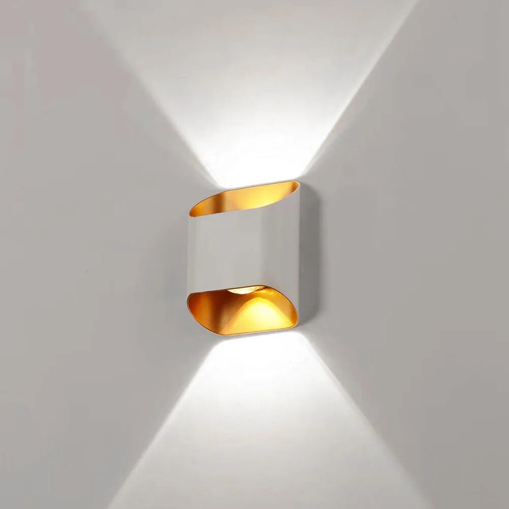 White up down wall sconce lit on a pale wall showing two beams