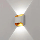 White up down wall sconce lit on a pale wall showing two beams