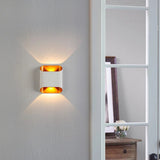 White up down wall sconce lit on a wall beside a ladder shelf