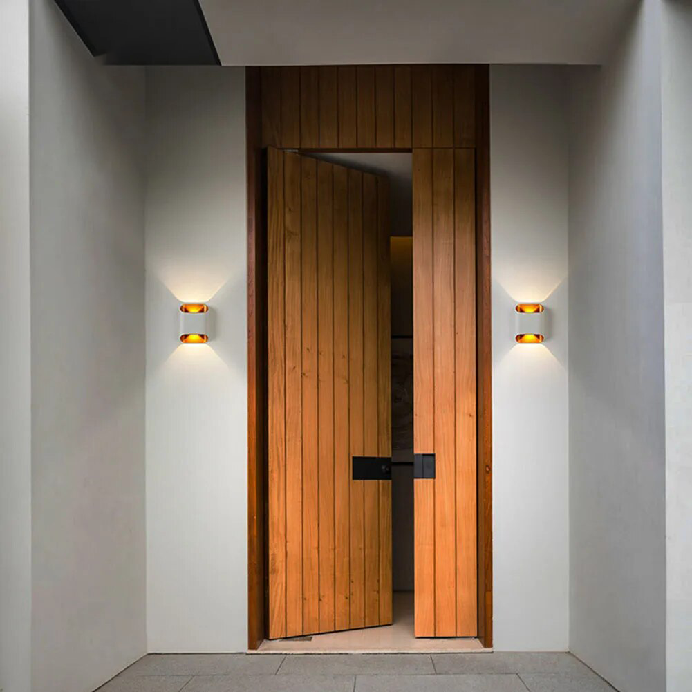 Two up down wall sconces lit either side of a hallway doorway