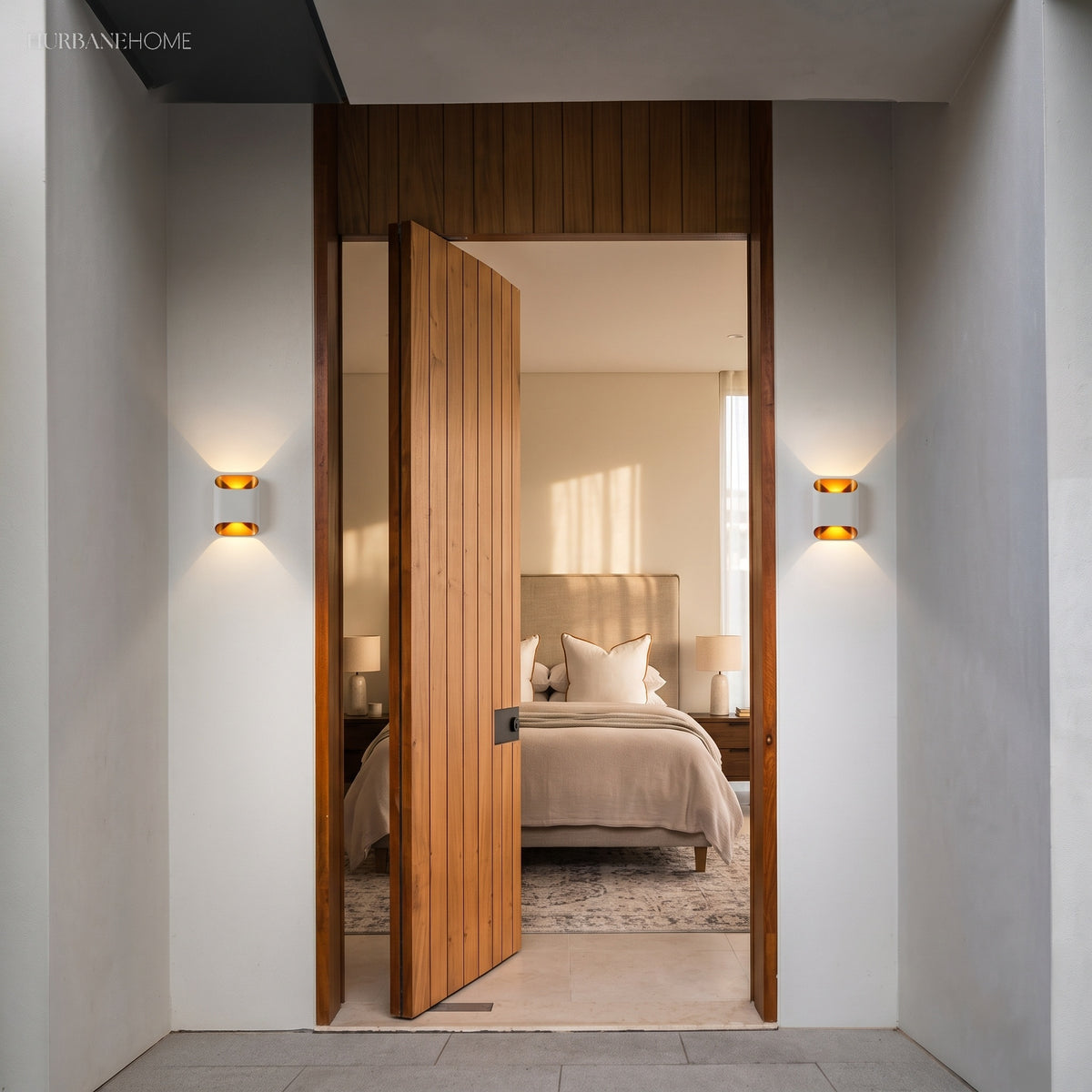 Two up down wall sconces lit either side of a timber front door