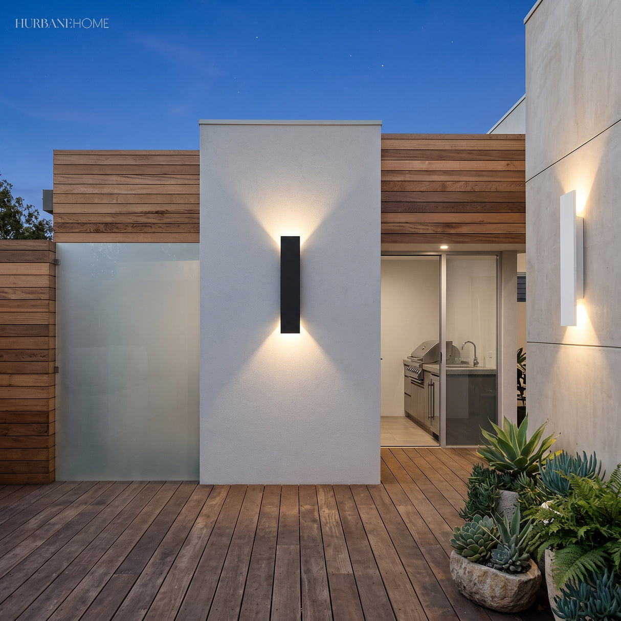 Tall black outdoor wall sconce and a white unit lighting a modern timber facade