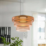 Amber three-layer glass pendant light in a bright white living room with a plant