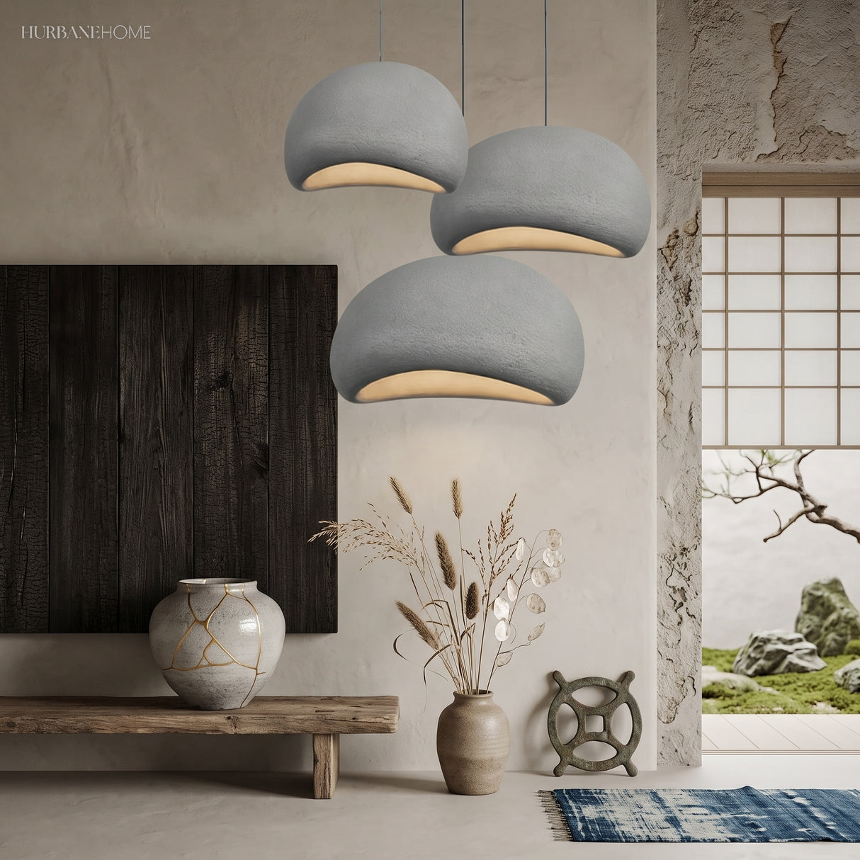 Grey pebble shaped pendant lights hanging in a minimalist room