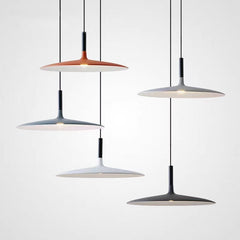 Four saucer pendants hung at different heights on a plain wall