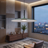 Green saucer pendant lit above a sideboard by a city window