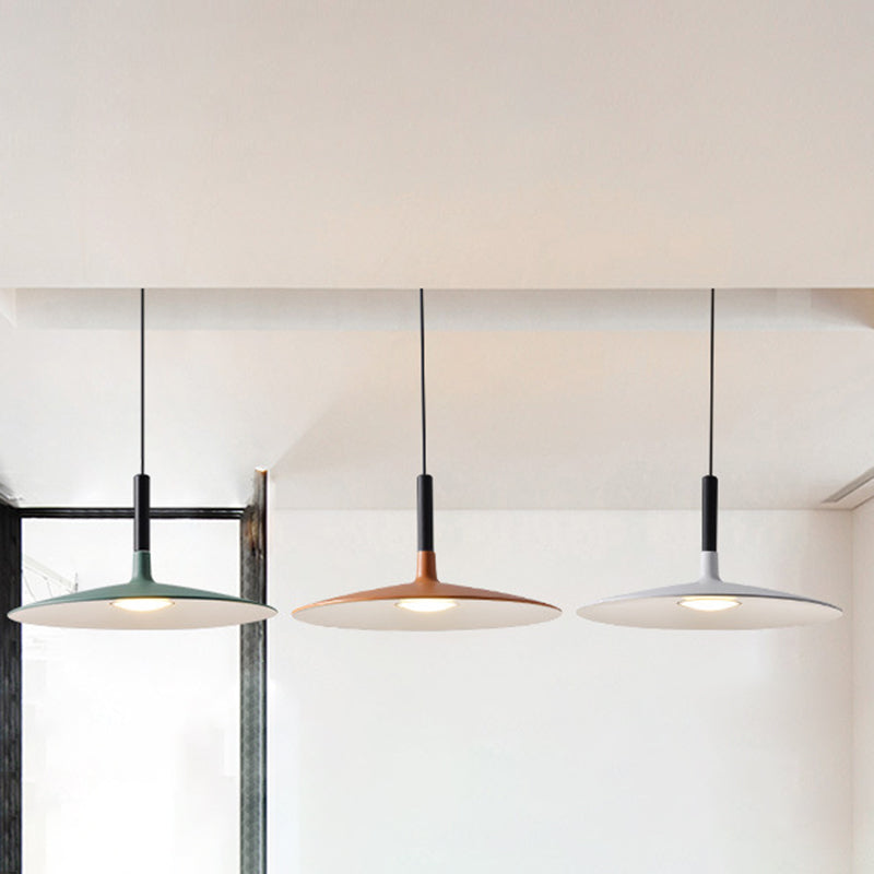 Green, orange and white saucer pendants hanging by a window