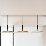 Green, orange and white saucer pendants hanging by a window