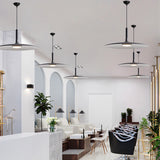 Three saucer pendants lit in a bright open plan living space