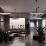Two white saucer pendants lit in an open lounge with plants